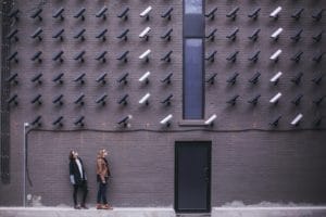 Two Ladies Leaning In A Wall Full of CCTV